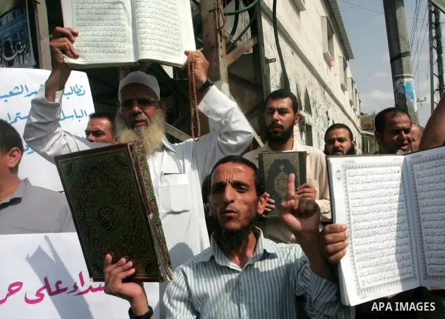 Palestinian men hold the holy Qur'an book during a demonstration to condemn the burning of mosque and Koran Sharif 'the holy Qur'an book' , in Rafah southern Gaza Strip on Oct. 5, 2010 . The Jewish settlers burned a mosq...