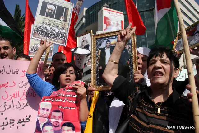 Palestinians hold pictures of the Secretary-General of the PFLP, Ahmad Saadat during a protest calling for the release of Palestinian prisoners from Israeli jails in the West Bank city of Nablus, Tuesday, Oct. 5, 2010. P...