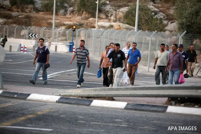 Palestinian workers walk to cross the Isreali controlled Modiin ( Bet seira ) checkpoint, between the West Bank and the Jewish settlement of Modiin Illit and all of Israeil , as they head to work in Israel and nearby set...