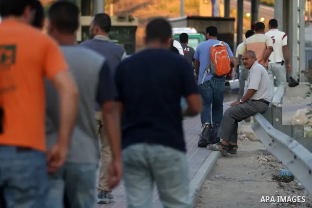 Palestinian workers wait to cross the Isreali controlled Modiin ( Bet seira ) checkpoint, between the West Bank and the Jewish settlement of Modiin Illit and all of Israeil , as they head to work in Israel and nearby set...
