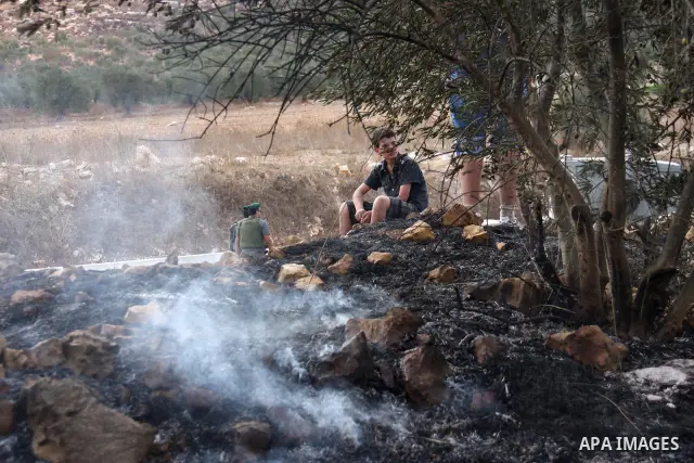 Palestinian farmers from the village of Hawara extinguish fire at their olives tree grove that was allegedly set ablaze by Jewish settlers from the nearby settlement of Yitzhar in the northern West Bank on October 7, 201...