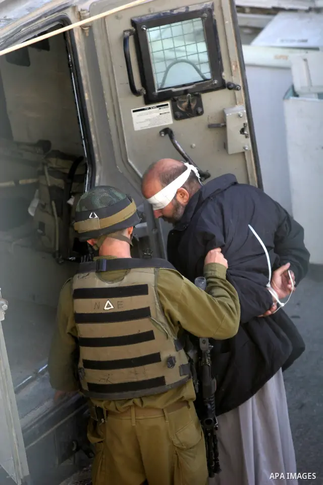 Israeli soldiers detain a Palestinian after an overnight raid in the West Bank city of Hebron, Friday, Oct. 8, 2010. Israeli troops killed two senior Hamas militants in an early-morning raid in the city on Friday, the Is...