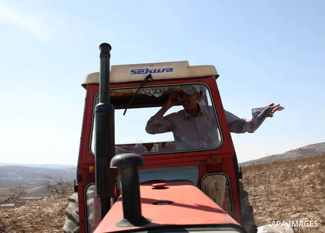 A Palestinian farmer stands in his truck crashed by Jewish settlers who attacked Palestinian farmers during pick olives in their agricultural fields in the West Bank village of Hawara, near Nablus on Oct. 10, 2010 . Phot...
