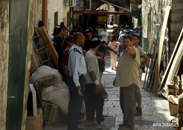 Israeli soldiers guard right-wing Jews who are removing furniture from a Palestinian home in Jerusalem's Old City on 10 October 2010 and loading it onto a small tractor to cart it away. An Israeli court order has forced...