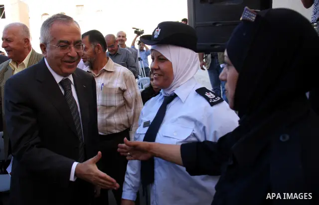 Palestinian Prime Minister Salam Fayyad shakes hands with a Palestinian policewomen, during a visit in the West Bank city of Nablus, Tuesday , Oct. 12, 2010. Israel's top leadership doubts a peace deal with the Palestini...
