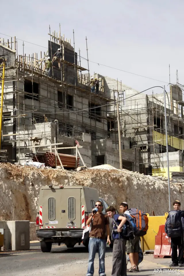 Palestinians work on a housing unit under construction site in settlement of Kiryat Arba , close to the West Bank town of Hebron , on Oct 17,2010 . Two days after reported plans to build 238 new settler homes in annexed...