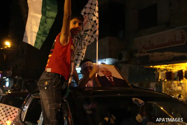 Palestinian youths wave with Palestinian flags and the flags of Fatah party during a march in support to the Palestinian President Mahmoud Abbas, in the West Bank city of Ramallah, on Oct. 18, 2010. Photo by Issam Rimawi