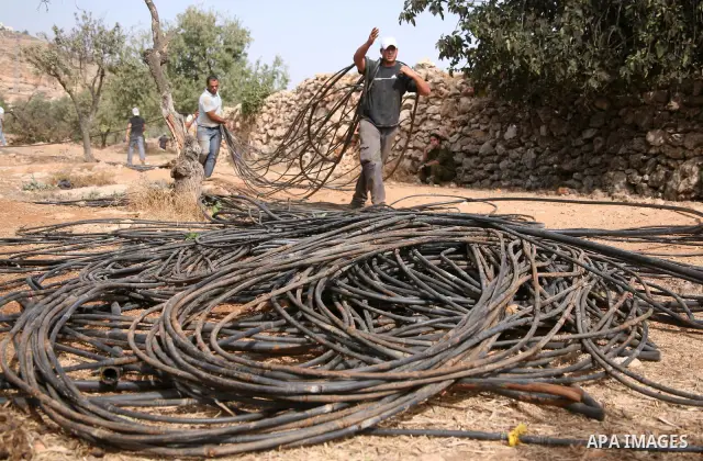 Arab-Israeli employees working with the Israeli army to remove the irrigation system from a Palestinian field near the Israeli settlement of Kiryat Arba on October 21, 2010 on the outskirts of Hebron, in the occupied Wes...