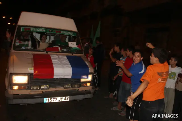 Pro-Palestinian activists recieve a cheering welcome by Palestinians upon the arrival of an aid convoy at the Rafah border crossing in the southern Gaza Strip, on 21 October 2010. An aid convoy carrying over 300 internat...