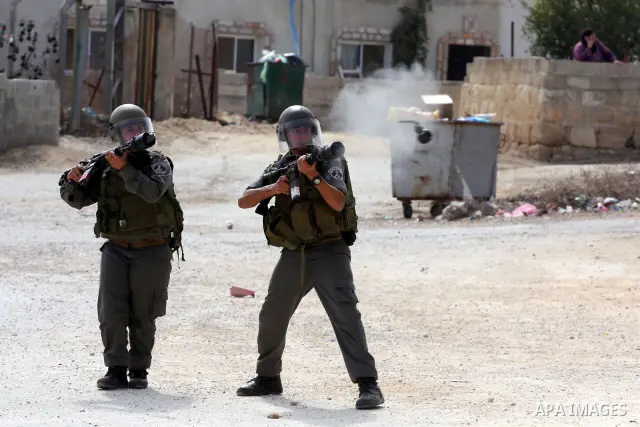 Israeli border policemen fire tear gas canisters towards Palestinians during clashes in the West Bank village of Nabi Saleh, on 22 October 2010. Palestinians protest weekly against the neighbouring Jewish settlement of H...