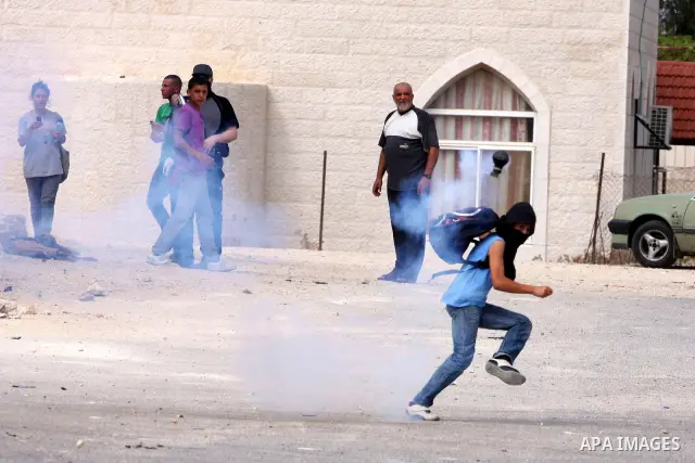 Israeli border policemen fire tear gas canisters towards Palestinians during clashes in the West Bank village of Nabi Saleh, on 22 October 2010. Palestinians protest weekly against the neighbouring Jewish settlement of H...
