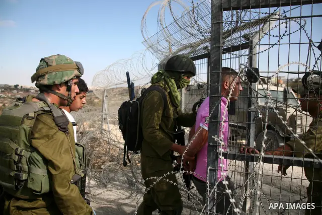 Israeli forces arrest Palestinian youths during a demonstration by Palestinian, Israeli and foreign activists against the demolishing of farm land to be used in the construction of Jewish settlements near the existing Is...