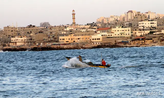Palestinian fishermen ride their boat during sunsit at Gaza port on Oct. 24,2010. Photo by Ashraf Amra