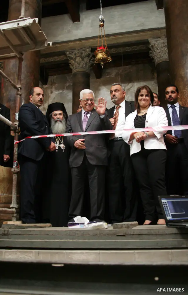 Palestinian President Mahmud Abbas is flanked by Greek Orthodox Patriarch of Jerusalem Theophilos III and other unidentified local officials during his visit on 25 October 2010 to the Church of the Nativity, believed by...