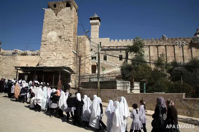 Israeli soldiers check Muslim school students at the old City in the West Bank city of Hebron on October 28, 2010. Photo by Najeh Hashlamoun