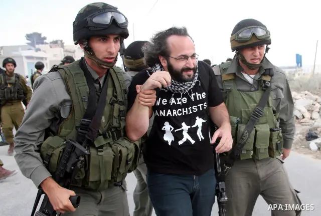 An international activist is detained by Israeli border police during a protest against the controversial Israeli barrier in the West Bank village of al-Masarah, near Bethlehem, October 29, 2010. Israel says the barrier...