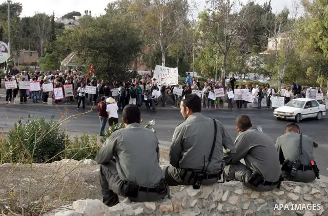 Palestinian, left-wing Israeli and foreign peace activists hold anti-settlement and occupation placards outside a Palestinian house occupied by Jewish settlers in east Jerusalem's Sheikh Jarrah neighborhood during the we...