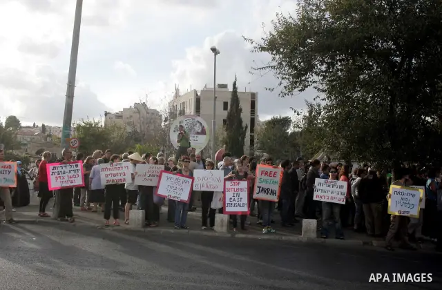 Palestinian, left-wing Israeli and foreign peace activists hold anti-settlement and occupation placards outside a Palestinian house occupied by Jewish settlers in east Jerusalem's Sheikh Jarrah neighborhood during the we...