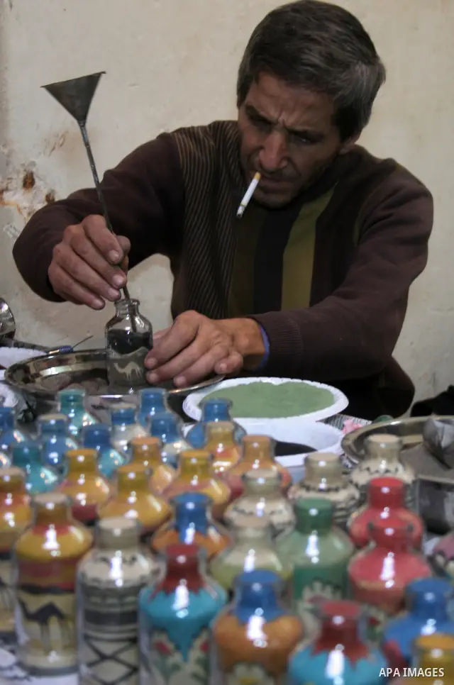 The painter , Mohammed Awawdeh and his assistant paint with sand in a suburb of the Old City of Hebron on Oct. 31,2010 . Awawdeh tries through his drawings is promotion and support the tourism in the old town and enters...