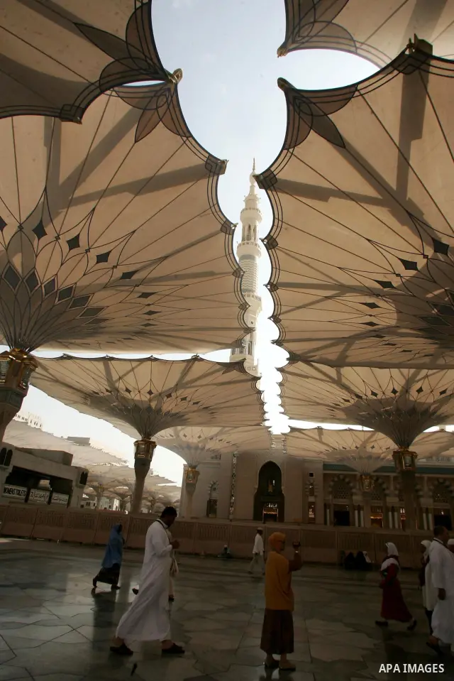 Muslim pilgrims walk outside the Prophet Mohammed Mosque in the Saudi holy city of Medina on November 2, 2010. More than three million Muslims are expected to converge on the holy cities of Mecca and Medina in western Sa...