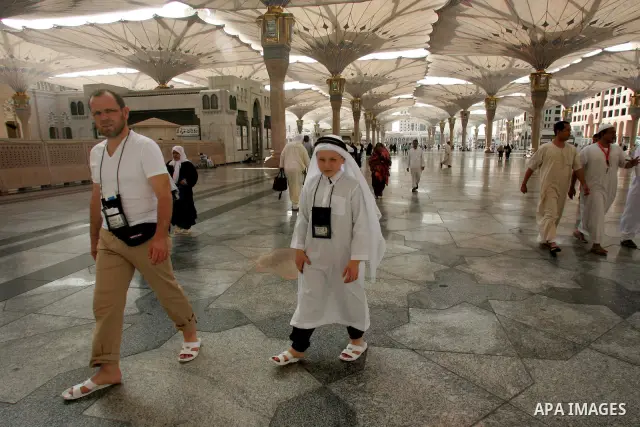 Muslim pilgrims walk outside the Prophet Mohammed Mosque in the Saudi holy city of Medina on November 2, 2010. More than three million Muslims are expected to converge on the holy cities of Mecca and Medina in western Sa...