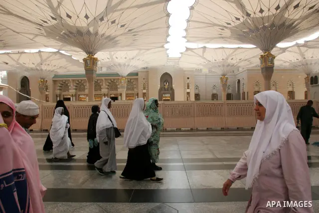 Muslim pilgrims walk outside the Prophet Mohammed Mosque in the Saudi holy city of Medina on November 2, 2010. More than three million Muslims are expected to converge on the holy cities of Mecca and Medina in western Sa...
