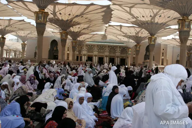 Muslim pilgrims attend Friday prayers outside the Prophet Mohammed Mosque in the Saudi holy city of Medina on November 5, 2010. More than three million Muslims are expected to converge on the holy cities of Mecca and Med...