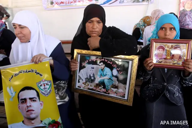 Palestinian women and children hold pictures of jailed relatives during a protest calling for the release of Palestinian prisoners from Israeli jails at the Red Cross office in Gaza City on November 8,2010 . Photo by Moh...