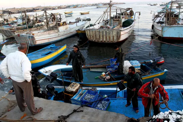 Palestinian fishermen carry their catch after a night at the sea in the port of Gaza City on Nov. 9,2010. Fishermen, suffer from the tightening of the Israeli siege imposed on Palestinian fishermen a forbidden fishermen...