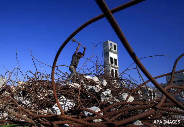 Palestinian workers collect scrap metal from the rubble of a hotel in Gaza City that was destroyed during Israel's three-week offensive nearly two years ago November 15, 2010. Thousands of Gazans, mainly young men and bo...