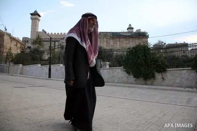 A Palestinian man walks near the Ibrahimi mosque during a special prayer on the first day of Eid al-Adha in the West Bank city of Hebron on Nov.16,2010. Muslims around the world celebrate Eid al-Adha to mark the end of t...