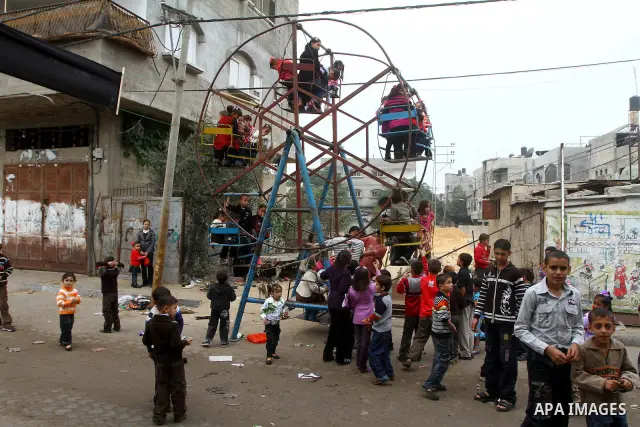 A Palestinian children enjoy a ride in an amusement park on the second day of the Muslim holiday of Eid al-Adha in Gaza City in Nov. 17, 2010. Muslims around the world celebrate Eid al-Adha to mark the end of the haj by...