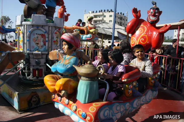 Palestinians enjoy a ride in an amusement park in the West Bank city of Ramallah on the second day of Eid al-Adha,on, November, 17, 2010. as Muslims worldwide commemorate Eid al-Adha, or the Feast of the Sacrifice, marki...
