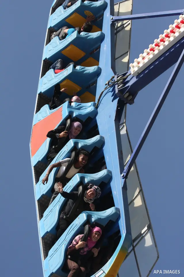 Palestinians enjoy a ride in an amusement park in the West Bank city of Ramallah on the second day of Eid al-Adha,on, November, 17, 2010. as Muslims worldwide commemorate Eid al-Adha, or the Feast of the Sacrifice, marki...
