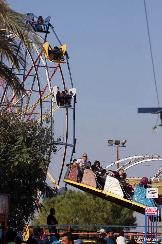 Palestinians enjoy a ride in an amusement park in the West Bank city of Ramallah on the second day of Eid al-Adha,on, November, 17, 2010. as Muslims worldwide commemorate Eid al-Adha, or the Feast of the Sacrifice, marki...