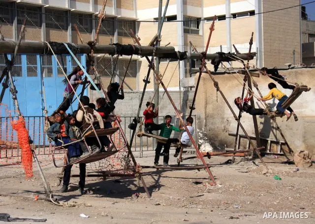 Palestinian refugee children enjoy a ride on swings put up in the Askar refugee camp outside the West Bank city of Nablus ,Wednesday, Nov. 17, 2010. as Muslims worldwide commemorate Eid al-Adha, or the Feast of the Sacri...