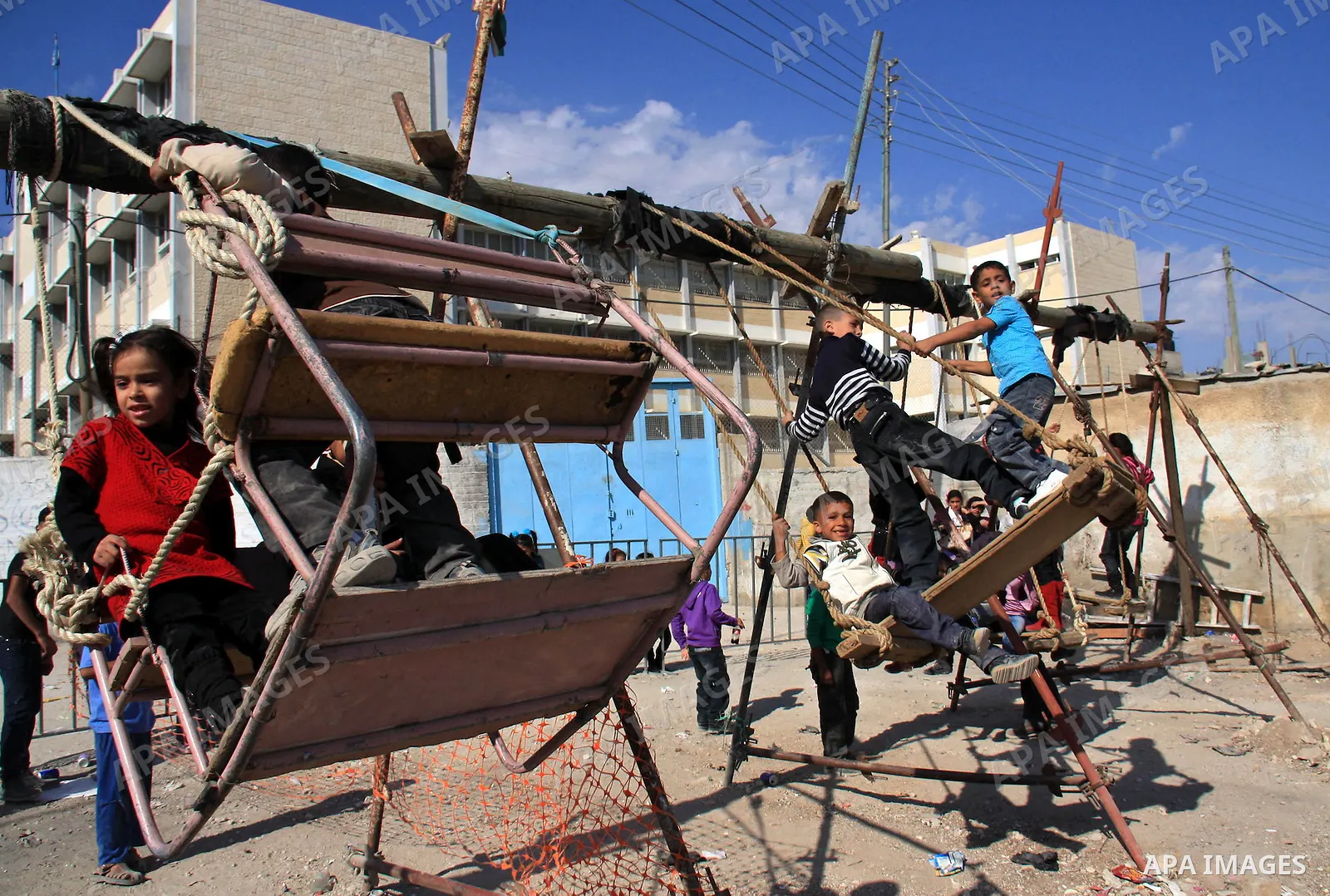 Palestinian refugee children enjoy a ride on swings put up in the Askar refugee camp outside the West Bank city of Nablus ,Wednesday, Nov. 17, 2010. as Muslims worldwide commemorate Eid al-Adha, or the Feast of the Sacri...