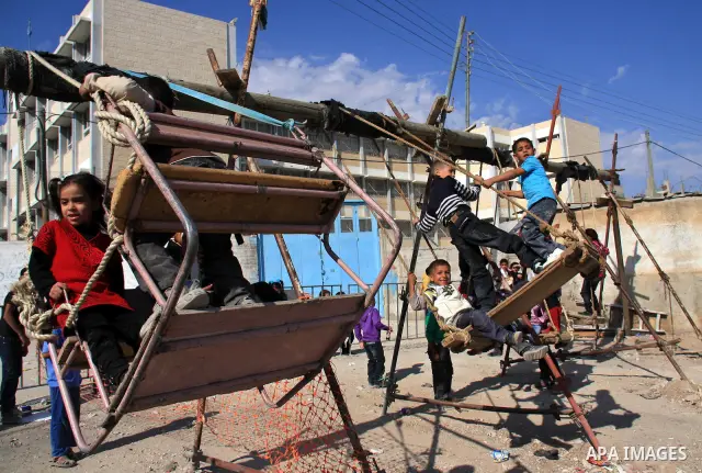 Palestinian refugee children enjoy a ride on swings put up in the Askar refugee camp outside the West Bank city of Nablus ,Wednesday, Nov. 17, 2010. as Muslims worldwide commemorate Eid al-Adha, or the Feast of the Sacri...