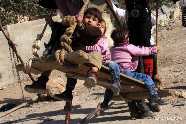 Palestinian refugee children enjoy a ride on swings put up in the Askar refugee camp outside the West Bank city of Nablus ,Wednesday, Nov. 17, 2010. as Muslims worldwide commemorate Eid al-Adha, or the Feast of the Sacri...