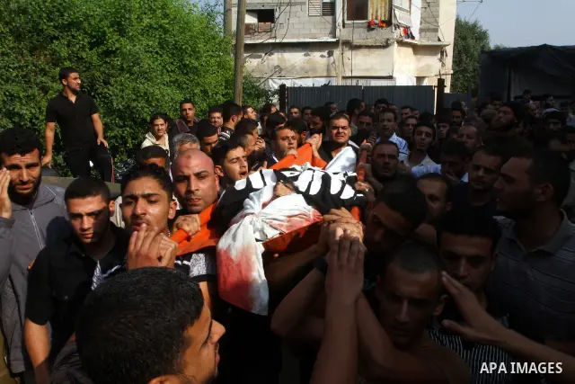 Palestinian mourners carry the body of Islam Yassin during his funeral in the Jabalia refugee camp, northern of Gaza Strip, on November 18, 2010. Islam and his brother Mohammed were killed the previous evening by an Isra...