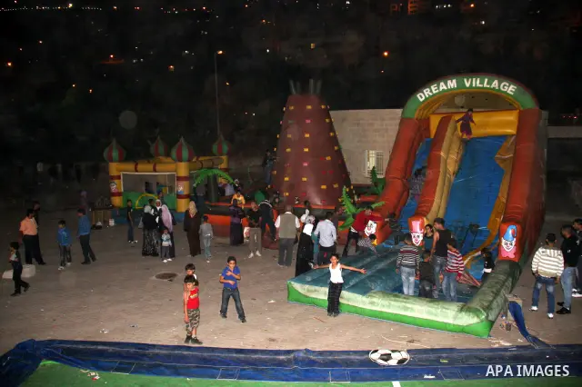 Palestinians enjoy a ride in an amusement park in the West Bank city of Nablus , Friday, Nov. 19, 2010 Muslims worldwide celebrate Eid al-Adha, or the Feast of the Sacrifice commemorating the biblical story of Abraham Ph...
