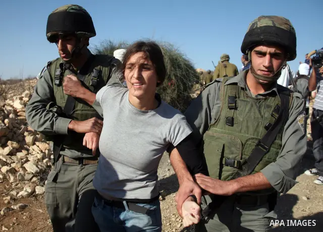 Israeli soldiers disperse foreign activists during a demonstration by Palestinian, Israeli and foreign activists against the demolishing of farm land to be used in the construction of Jewish settlements near the existing...
