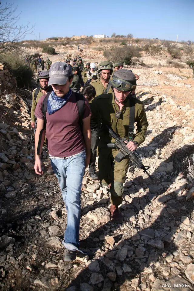 Israeli soldiers disperse foreign activists during a demonstration by Palestinian, Israeli and foreign activists against the demolishing of farm land to be used in the construction of Jewish settlements near the existing...
