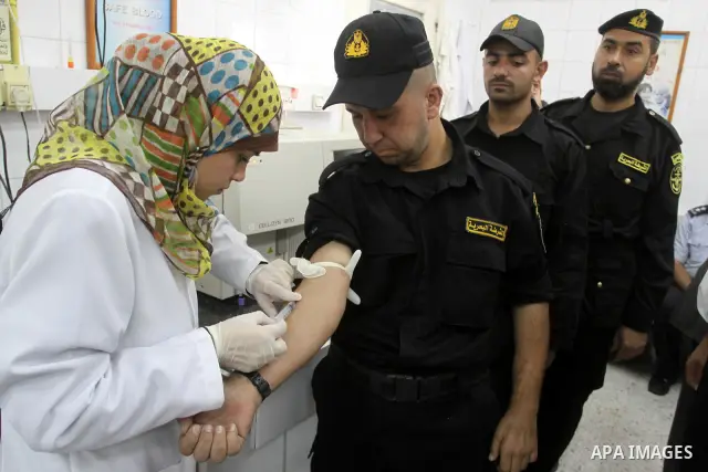 A member of the Palestinian security in Gaza strip , donates blood during a police campaign to donate blood at Al-Shifa hospital , in Gaza City on Nov. 21,2010 . Photo by Mohammed Asad
