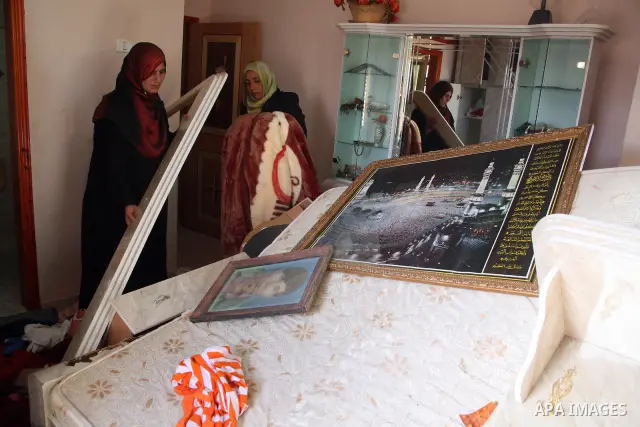 A Palestinian woman inspects the damages at her house for Hasan Awlad Mohammad after an Israeli military operation in Dura village near the West Bank city of Hebron on November 24, 2010 . Photo by Najeh Hashlamoun