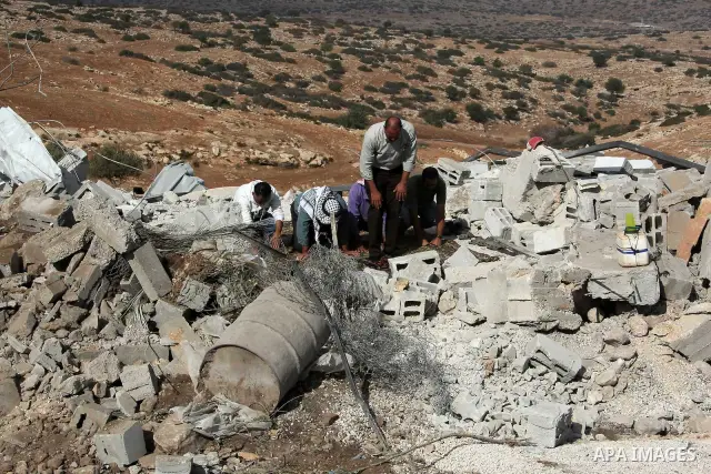 Palestinians pray on the rubble of a mosque which was demolished by the Israeli army in the West Bank village of Yarza near the West Bank town of Tubas, where the army destroyed at least five buildings due to lack of Isr...