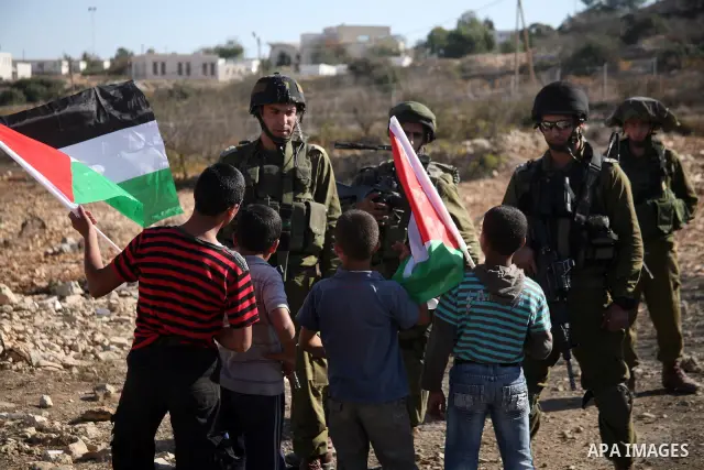 Israeli soldiers stand guard during a demonstration by Palestinian, Israeli and foreign activists against the demolishing of farm land to be used in the construction of Jewish settlements near the existing Israeli settle...