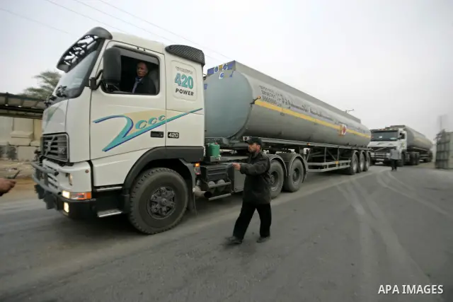 .A Palestinian worker walks past an oil trucks in the Palestinian Rafah border crossing while the oil trucks are preparing to go to bring fuel from crossing Karem Salem Israeli , in the southern Gaza Strip on November 29...
