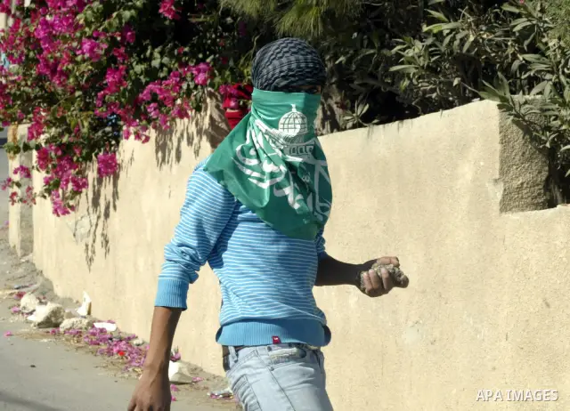 A Palestinian youth throws stones at Israeli soldiers after a house was demolished by Israeli municipality bulldozers for allegedly being built illegally in the Arab east Jerusalem neighbourhood of Issawiyah on November...