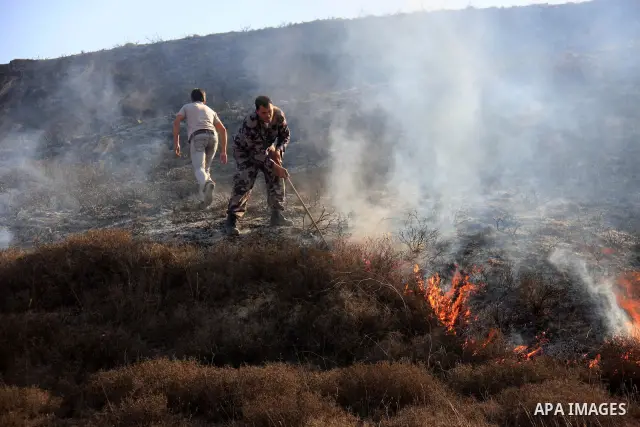 A Palestinian man tries to put out fires after fields were set ablaze in the village of Burin village, near the Jewish settlement of Yitzhar in the northern West Bank Nov. 30, 2010. According to Palestinian villagers, Je...